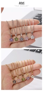 Detailed macro view of five-petal flower pendants with colorful zircons on metal chains