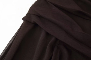 Close-up of pleated semi-transparent fabric in dark coffee brown for high-quality dresses