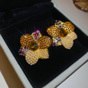 Detailed macro view of vintage flower earrings with pearls and pavé yellow rhinestones