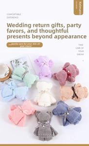 Detail of coral fleece bear towels with pearl bows in various soft pastel colors