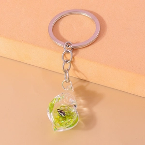 Detailed view of heart-shaped glow-in-the-dark keychain with green artistic patterns