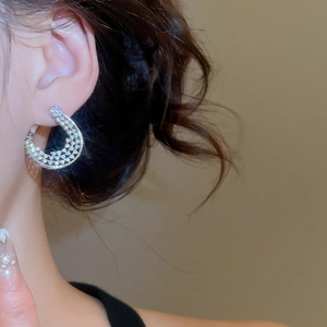 Gros plan de boucles d'oreilles créoles plaquées or 18K avec zircone sur un mannequin