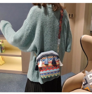 Ethnic style crossbody bucket bag with colorful woven patterns and tassel details shown on model