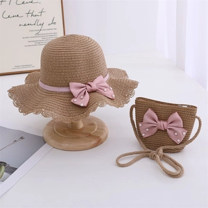 Detail of child straw hat and matching bag set with pink bows and pearls
