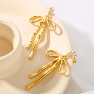 18k gold plated stainless steel bow earrings with zircon tassel on beige ceramic base
