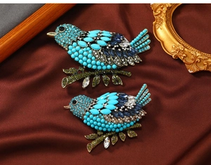 Detailed close-up of vintage magpie brooches with turquoise and blue rhinestones