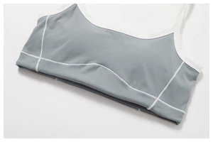 Détail d'un soutien-gorge de sport en tissu gris-bleu avec coutures contrastées blanches