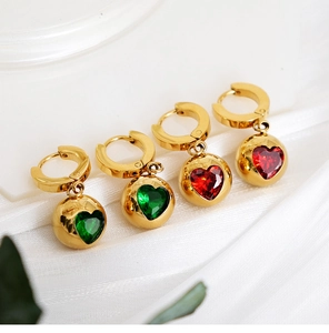 Détail de boucles d'oreilles dorées avec zircons en forme de cœur vert émeraude et rouge rubis
