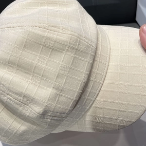 Close-up of beige newsboy hat showing detailed 3D checkered fabric texture and stitching