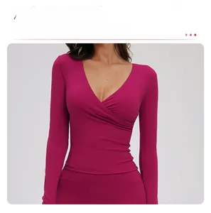 Detail of cross pleated waist design on long sleeve V-neck yoga top in magenta pink