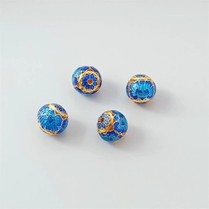 Macro view of four deep blue Cloisonne enamel round beads with gold floral patterns