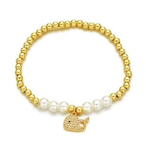 Golden beaded bracelet with white pearls and a sparkling zircon whale pendant