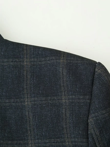 Detailed close-up of shoulder seam on high-quality dark grey plaid blazer for women