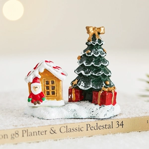 Miniature Christmas scene with Santa Claus, golden house and snowy tree decoration