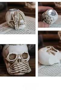 Detail of gothic skull candle holder with bone hand and vintage cracked resin finish