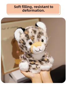 Detail of soft plush leopard toy being held, showing realistic whiskers and fur texture
