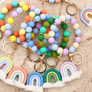 Close-up of rainbow silicone beaded wristlet keychain with gold clasp and woven tassel