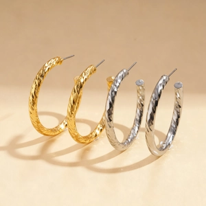 Textured C-shaped geometric hoop earrings in gold and silver finish with metallic shine