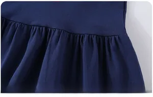 Detail of navy blue knitted girls dress showing elastic pleated hemline and fabric texture