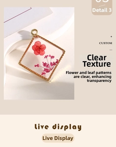 Macro detail of diamond-shaped gold resin pendant with embedded dried red and pink flowers