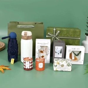 Detail of luxury gift set with thermal mug, umbrella, candles and soaps in a green box