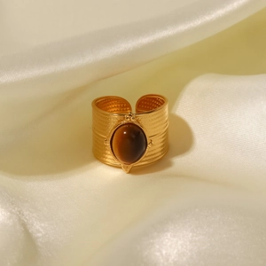 Detailed shot of an 18K gold stainless steel wide ring with an oval brown gemstone inlay
