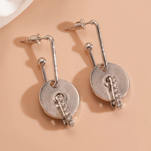 Detail of silver geometric round earrings with spiral texture and pavé set rhinestones