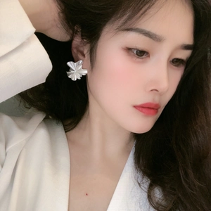 Elegant white ruffled petal earrings in silver-plated finish shown on a model