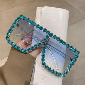 Detail of square oversized blue sunglasses featuring hand-set sparkling rhinestones