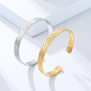 Detailed macro view of gold and silver cuff bracelets with fine honeycomb textured pattern