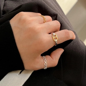 Close-up of stacked 925 sterling silver twist and chain rings on model fingers