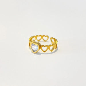 Macro shot of 18k gold plated stainless steel heart ring with green zircon stones