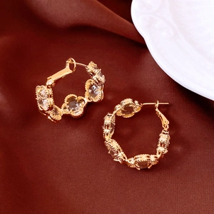 Gros plan détaillé de boucles d'oreilles créoles trèfle plaquées or 18 carats et verre