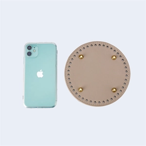 Macro view of 15cm circular PU leather bag base with gold studs and pre-punched holes