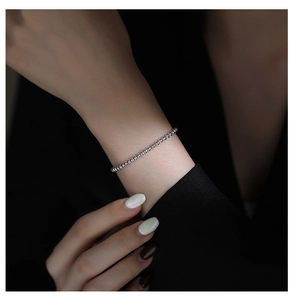 Detail of adjustable silver beaded bracelet on wrist with elegant high-polish finish