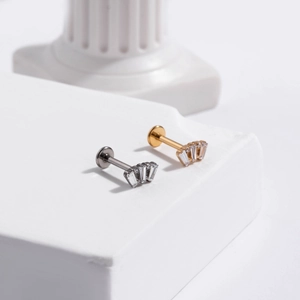 Close-up of gold and silver G23 titanium push-pin studs with fan-shaped zircon detail
