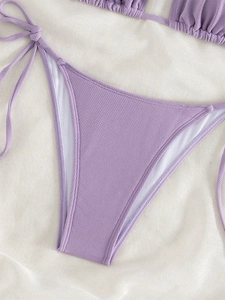 Detailed close-up of light purple ribbed fabric and side-tie design on bikini bottoms