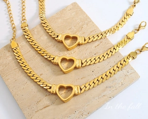 Detailed macro view of gold-plated hollow heart pendants on stylish curb chain jewelry