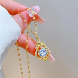 Macro shot of gold teardrop pendant featuring a blue central gemstone and pavé accents