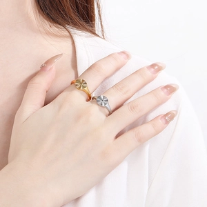 Detailed close-up of gold and silver textured sunflower rings on model hand