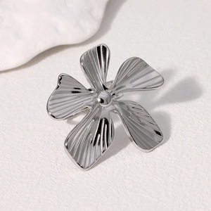 Bague fleur minimaliste en acier inoxydable argenté avec texture radiale sur papier blanc