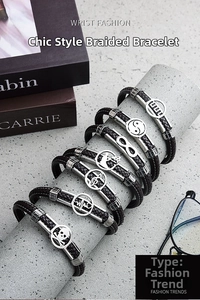 Detail of dark brown braided leather bracelets with various symbolic metal charms