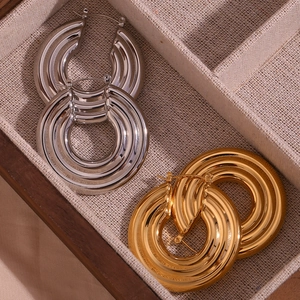 Detail of 18K gold and silver chunky textured hoop earrings in a jewelry box