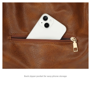 Detail view of back zipper pocket on brown leather tote bag with phone storage