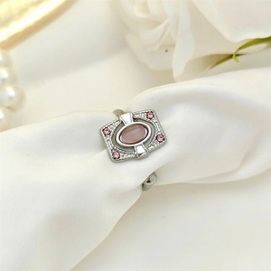 Vintage Art Deco stainless steel ring with pink oval gemstone on white silk fabric
