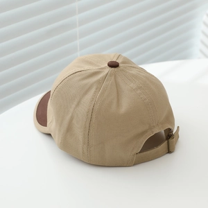 Detail view of khaki baby baseball cap featuring cotton twill texture and adjustable metal buckle