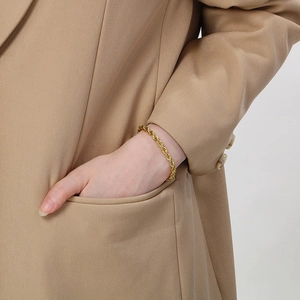 Detailed view of an 18K gold-plated stainless steel rope chain bracelet worn on wrist
