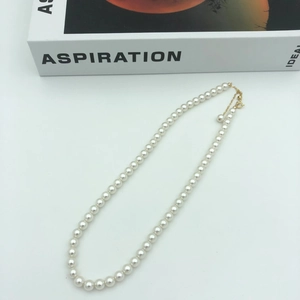 Detailed view of white round pearl necklace with adjustable 14k gold lobster clasp