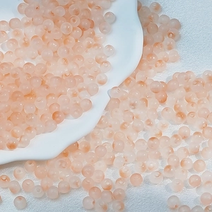 Macro shot of 6mm frosted peach glass beads for handmade DIY jewelry crafts