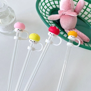 Macro detail of four colorful silicone mushroom straw covers on glass straws in a lifestyle setting